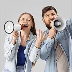 Excited man and woman shouting through megaphones against a light gray background.